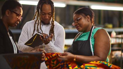 Textile industry employer and employees having a production meeting.
